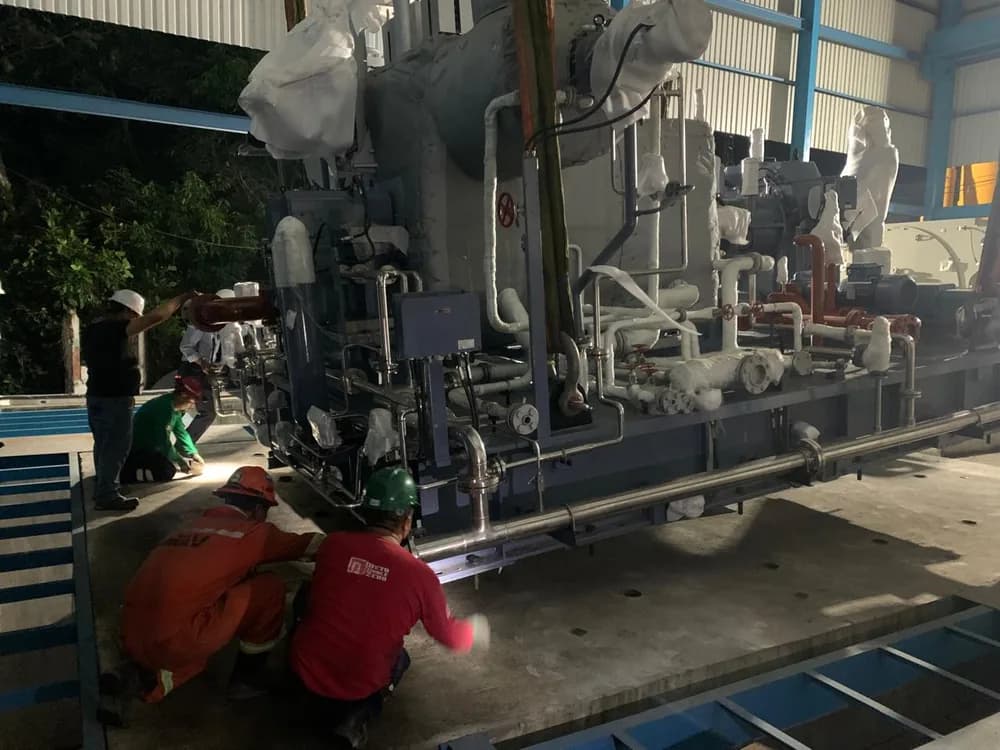 Grupo Möller crew setting a turbine skid on its base during a night installation