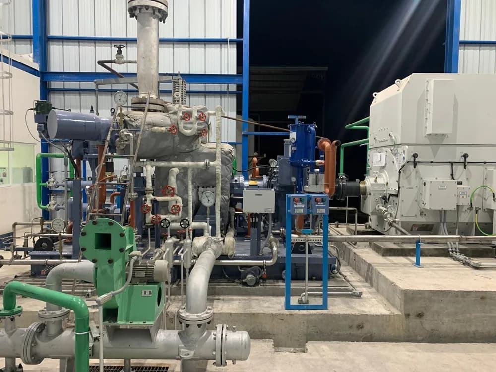 Cogeneration plant room with the turbine, piping and generator in the background
