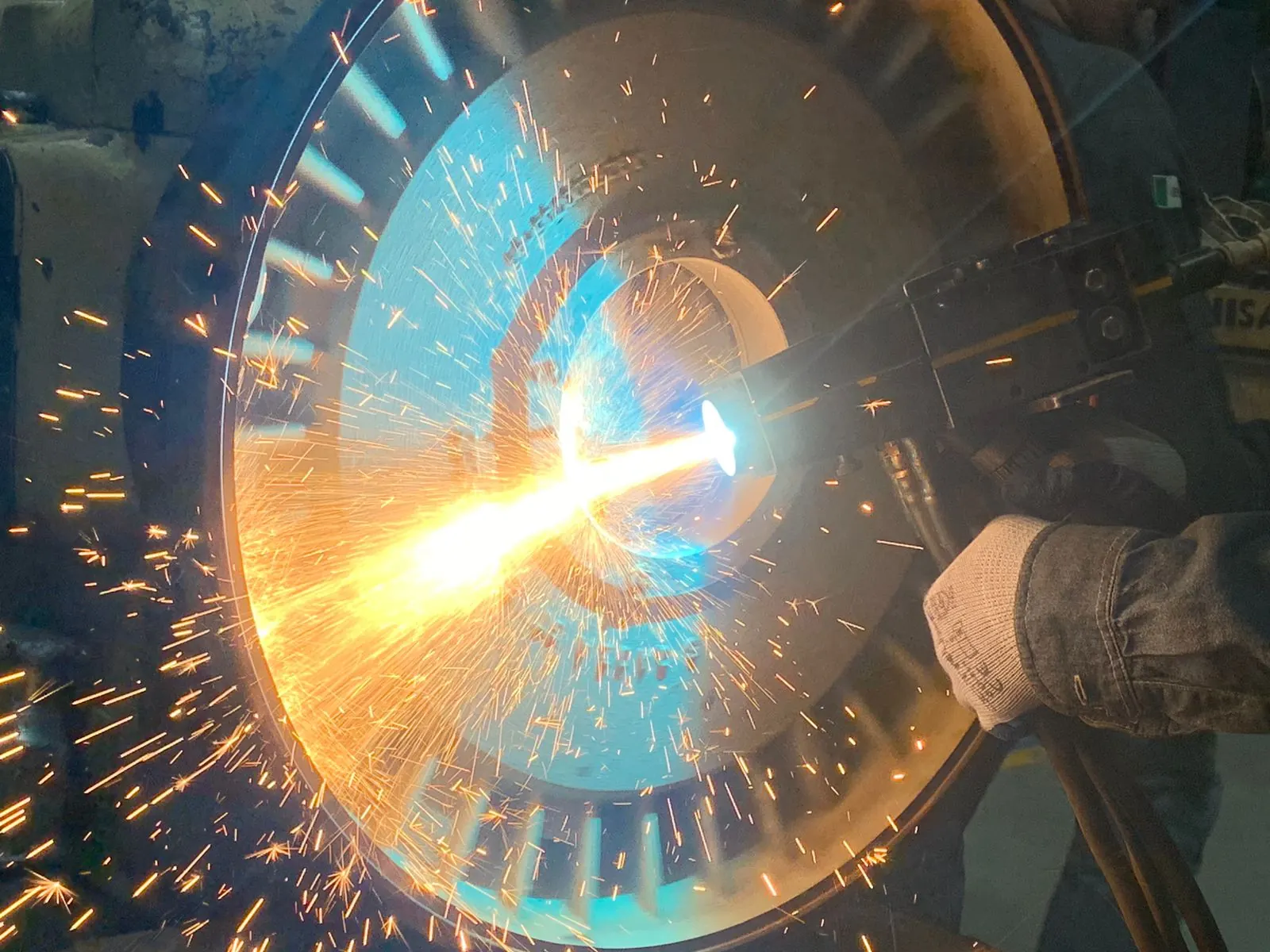Sparks flying from a rotor as a technician works on it in the shop