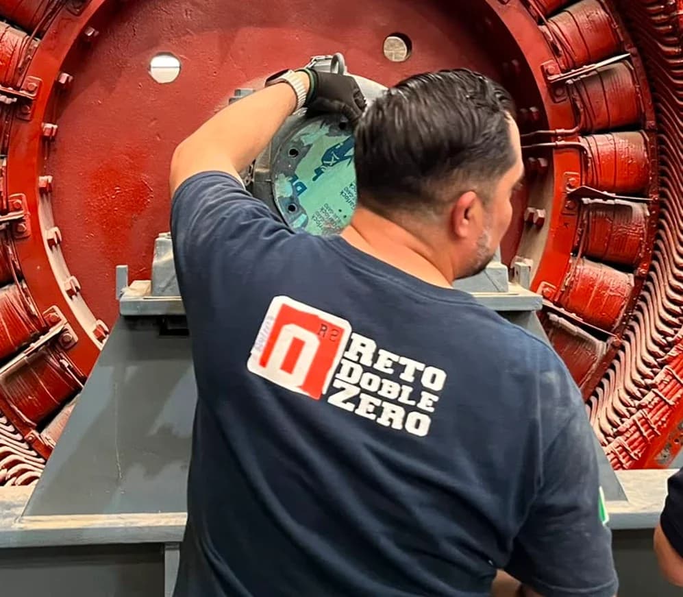 Grupo Möller technicians wearing Reto Doble Zero shirts working on a generator stator