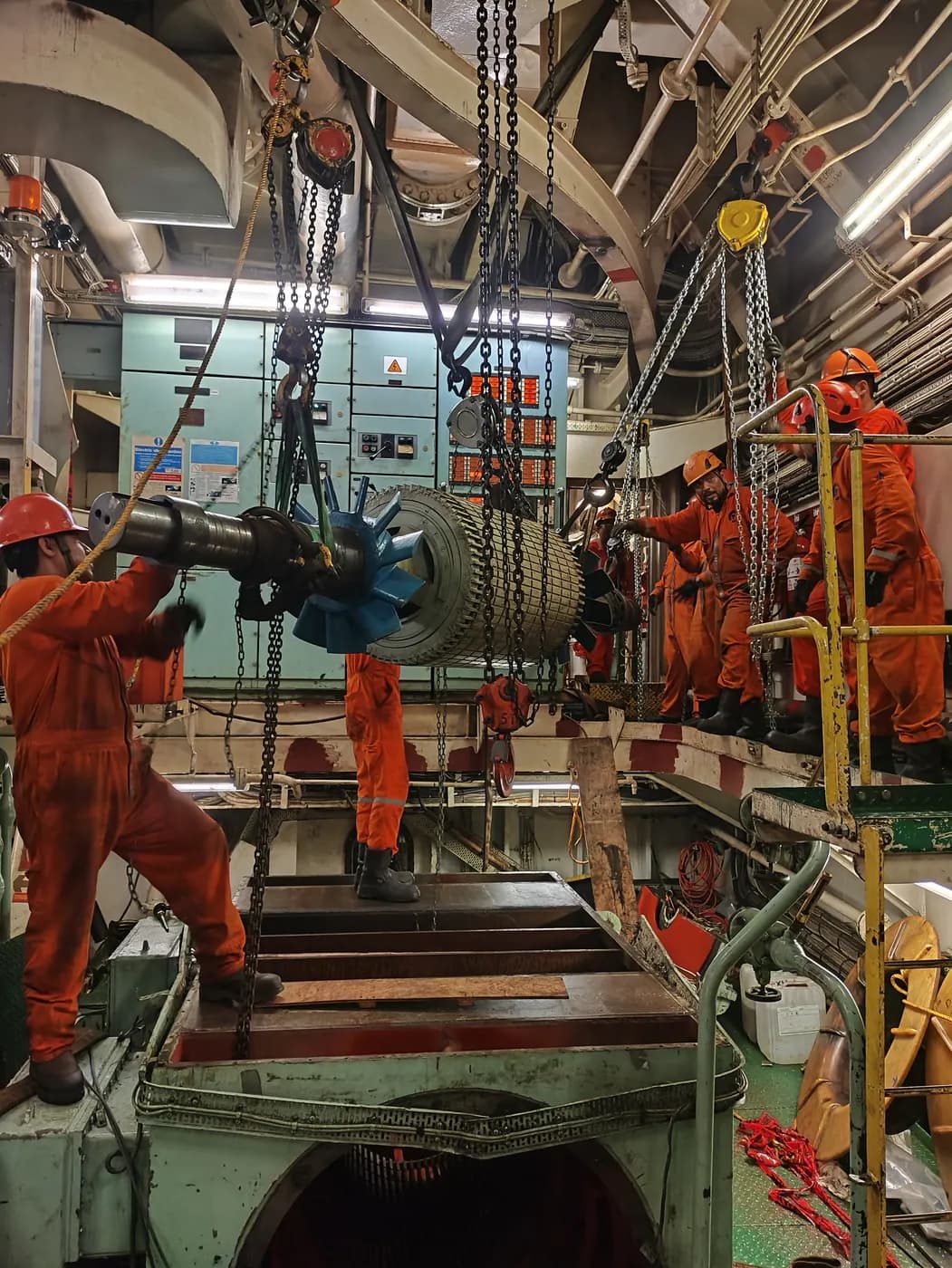Grupo Möller crew rigging a generator with hoists inside a ship's engine room